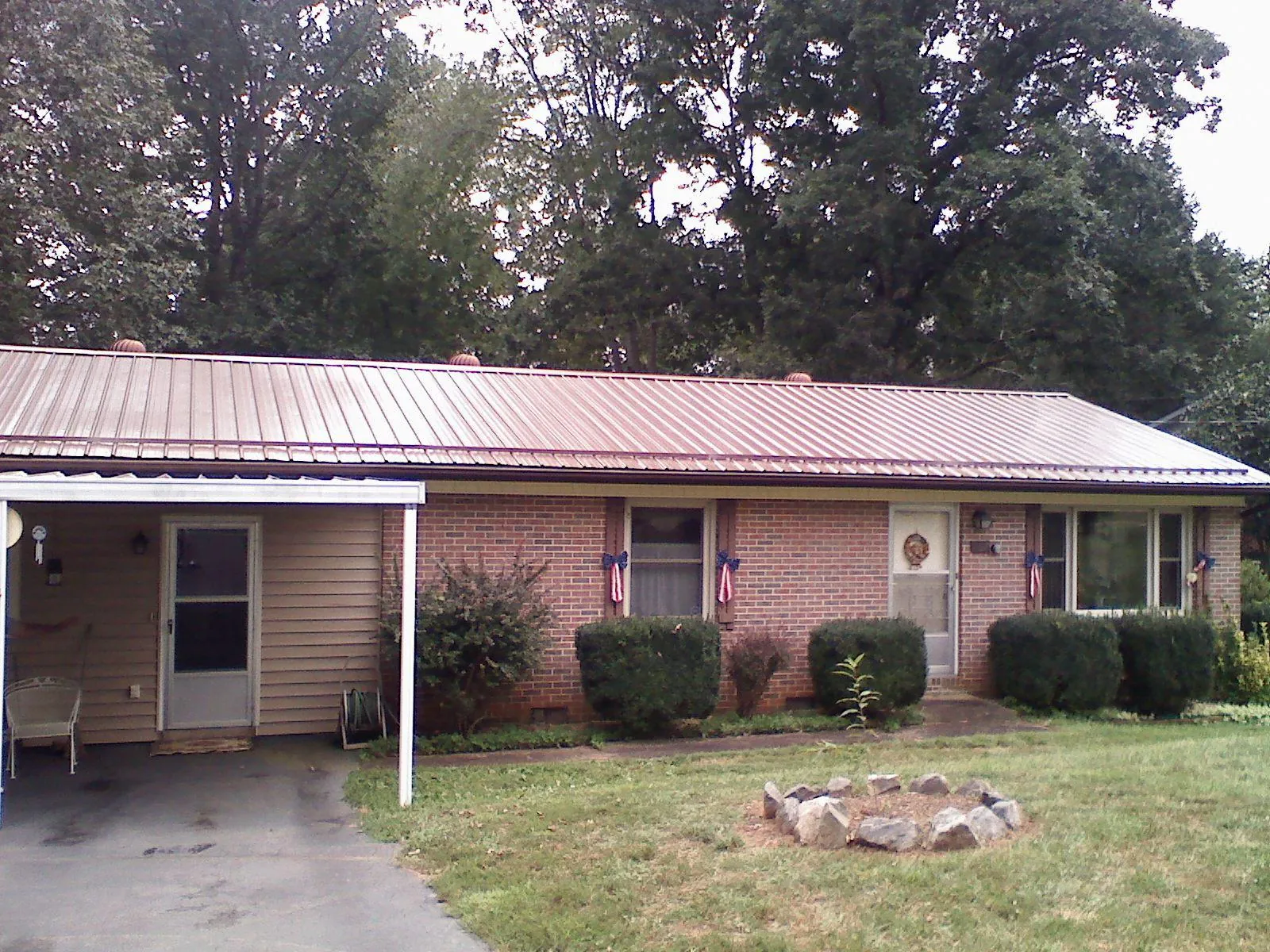 Bronze metal roof and carport on a brick ranch home — Roof Repair work by our crew in Grant